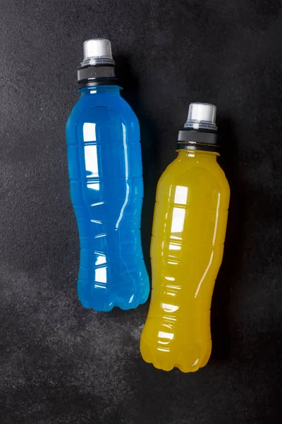 Isotonic energy drink. Bottles with blue transparent liquid, sport beverage on a black background — Stock Photo, Image