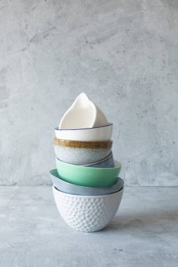 Gri arka plan üzerindeki bir yığında masadaki bulaşıkları temizleyin