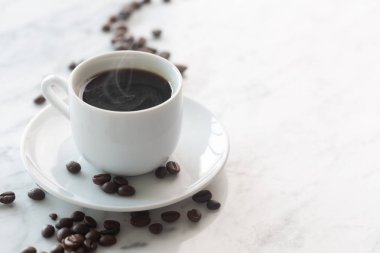 Bir masada geleneksel beyaz fincan espresso veya americano kahve Sıcak fincan