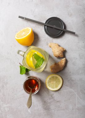 Gri Beton Arka Planda Limon ve Bal ile Cam kavanozda Zencefil Suyu