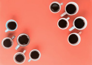 Mercan kırmızısı arka plandaki farklı bardaklarda kahve. Flatlay, neşeli gün konsepti