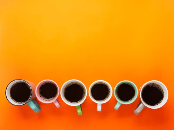 Caffè nelle diverse tazze sullo sfondo arancione brillante. Flatlay, concetto di giorno allegro — Foto Stock