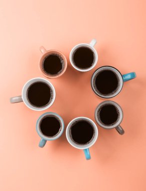 Pembe arka planda farklı bardaklarda kahve. Flatlay, neşeli gün konsepti