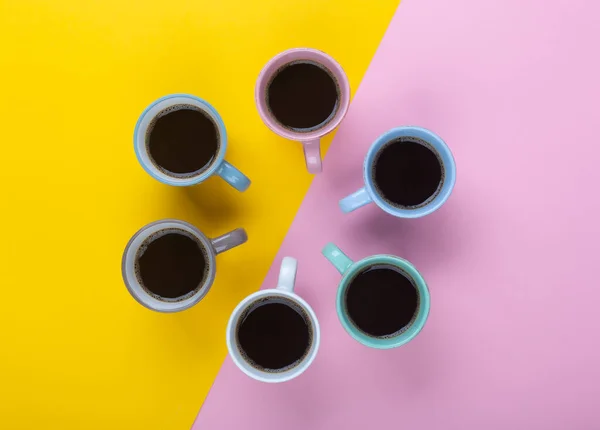 Café en las diferentes tazas en el fondo rosa y amarillo. Flatlay, concepto de día alegre —  Fotos de Stock