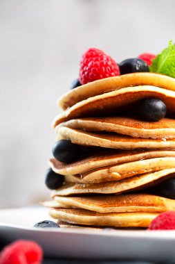 Kahvaltı için böğürtlenli krep, ahududu, nane ve bal.