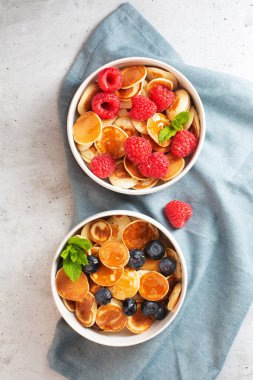 Kahvaltı için böğürtlenli, böğürtlenli, nane ve ballı küçük krepler.