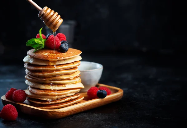 Pancakes with blueberries, raspberries, mint and honey for a breakfast — Stock Photo, Image