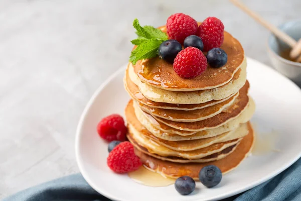 Pfannkuchen mit Blaubeeren, Himbeeren, Minze und Honig zum Frühstück — Stockfoto