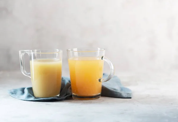 Glasses with Homemade Beef Bone Broth on a Gray background. Bones contain collagen, which provides the body with amino acids, which are the building blocks of proteins