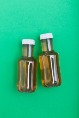 Bir şişe buzlu çay, yeşil arka planlı üst manzara.