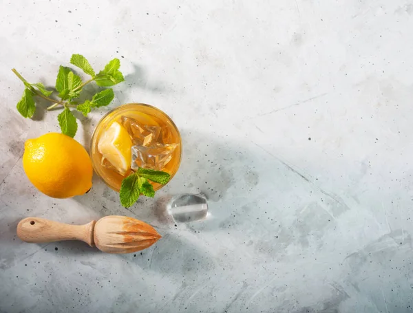 Thé glacé au citron sur fond gris béton avec menthe et glace, pose plate avec espace de copie — Photo