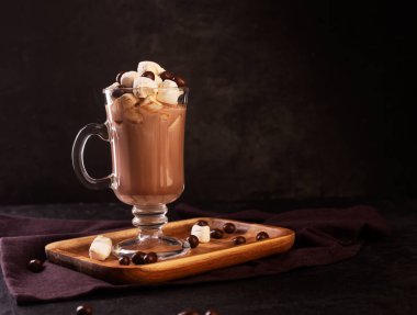 Koyu arkaplanda tarçınlı sıcak çikolata ve marshmallow fotokopi alanı, kopyalama alanı ile yan görünüm