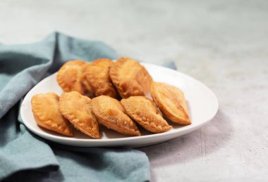 Tipik Kolombiya börekleri genellikle beton yüzeyde, yatay olarak baharatlı sosla servis edilir.