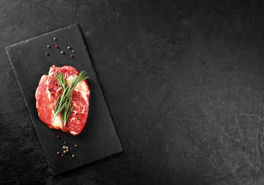 Biberiyeli biftek ve siyah arka planda biber.