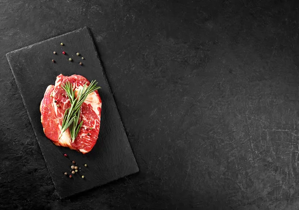 Biberiyeli biftek ve siyah arka planda biber.