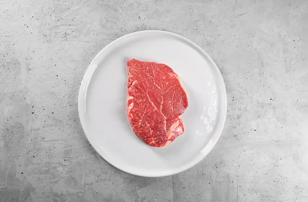 Nyers marhahús fehér tányéron, felülnézetből — Stock Fotó