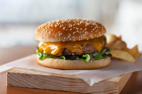 ウッドボード上の溶かしたチーズと新鮮な調理バーガー 水平方向 — ストック写真