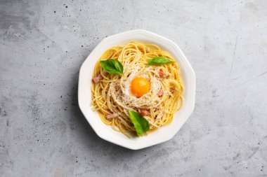 Yumurtalı İtalyan makarna, sert peynir, kurutulmuş domuz guanciale veya pancetta ve karabiber. Somut gri arkaplan