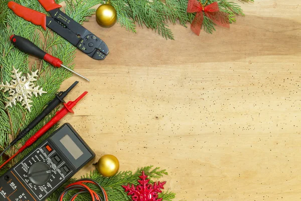 Elektrikçi araçları ve aletleri ve Noel dekorasyonları ahşap arka plan üzerinde