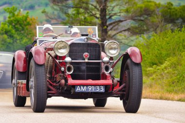 Spoleto yakınlarındaki Mille Miglia 2010 tarihi rallisinde 1928 yılından kalma klasik Mercedes-Benz SSK, manzaralı bir kırsal yolda iki sürücü ile yarışıyor. Spoleto, İtalya, 6 Mayıs 2010.