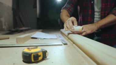 Yakın çekim elle zımpara kağıdıyla ahşap bir ürünü ovuyor, yavaş çekimde.