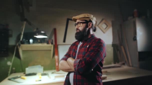 Retrato de un hombre barbudo serio con gafas, que está de pie con los brazos cruzados y mirando a la cámara — Vídeo de stock