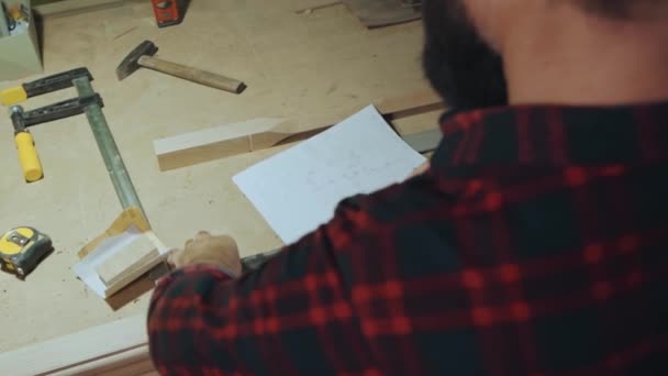 Un homme prend des mesures d'un produit en bois — Video