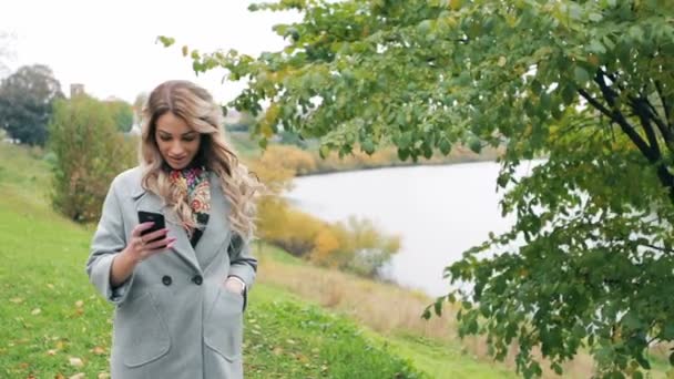 Blond tjej med smartphone och kreditkort gör shopping Stockvideo