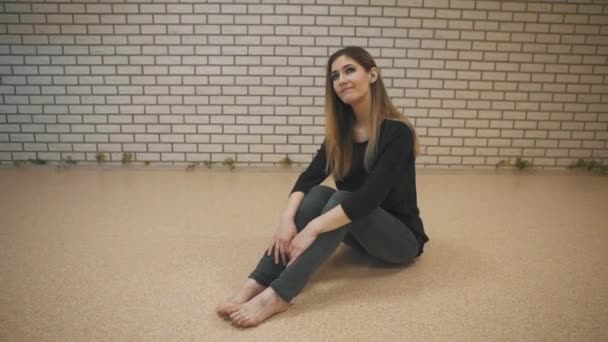 Όμορφη χορεύτρια κορίτσι κάθεται στο πάτωμα στο στούντιο ευρεία γωνία — Αρχείο Βίντεο