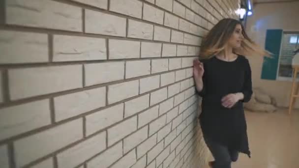 Danser. Jonge getalenteerde vrouw dansen en het uitvoeren van Freestyle dans voor een witte bakstenen muur. — Stockvideo