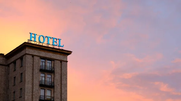 Viharzott és kiégett neon Hotel jel kigyulladt egy színes és drámai vörös és narancs ég naplementekor New Yorkban — Stock Fotó