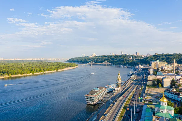 Вид с воздуха на реку Днепр, Киевские холмы и город Киев возле пешеходного моста, Украина. Ночной город, сумерки, подсветка — стоковое фото