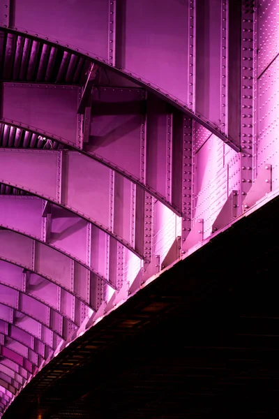 The part of modern abstract bridge construction in the purple lights of illumination. The Krymskiy bridge in Moscow