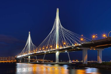 Neva Nehri ağzına güneş battıktan sonra mavi saat içinde daire Otoban yolu köprüsü. Petersburg şehir ve bitiş Körfez binalar gece görünümü