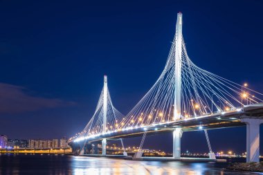 Neva Nehri ağzına güneş battıktan sonra mavi saat içinde daire Otoban yolu köprüsü. Petersburg şehir ve bitiş Körfez binalar gece görünümü