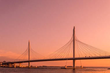 Neva Nehri ağzına gün batımı sırasında altın saat içinde daire Otoban yolu köprüsü. Petersburg şehir binaların ve bitiş körfez manzarasının akşam