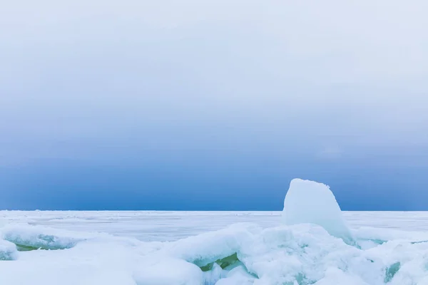 海の冬湾は雪と氷で覆われています 海と海岸に流氷のヒープの曇り空 白い表面と白と青の美しい風景 — ストック写真