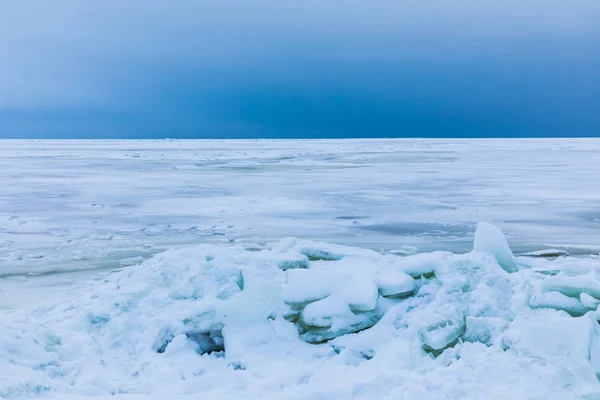 海の冬湾は雪と氷で覆われています 海と海岸に流氷のヒープの曇り空 白い表面と白と青の美しい風景 — ストック写真