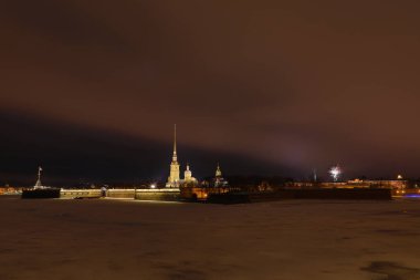 Peter ve Paul Fortress St. Petersburg, Rusya akşam veya gece ve Neva nehir kaplı buz ve kar bulutlu havalarda bir gökyüzünde havai fişek ile