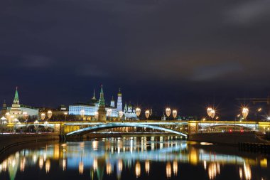 Işıklı Moskova Kremlin ve Bolshoy Kamenny köprü de güneş ışınları. Rusya Patriarshy Yaya Köprüsü'nden görüntüleyin. Mavi saat içinde kentsel peyzaj akşam