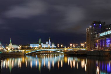 Işıklı Moskova Kremlin ve Bolshoy Kamenny köprü de güneş ışınları. Rusya Patriarshy Yaya Köprüsü'nden görüntüleyin. Mavi saat içinde kentsel peyzaj akşam