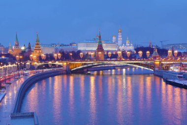 Işıklı Moskova Kremlin ve Bolshoy Kamenny köprü de güneş ışınları. Rusya Patriarshy Yaya Köprüsü'nden görüntüleyin. Mavi saat içinde kentsel peyzaj akşam