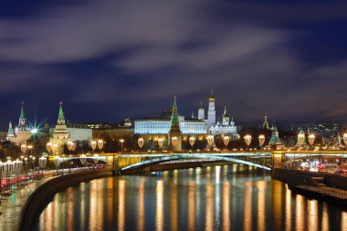 Işıklı Moskova Kremlin ve Bolshoy Kamenny köprü de güneş ışınları. Rusya Patriarshy Yaya Köprüsü'nden görüntüleyin. Mavi saat içinde kentsel peyzaj akşam