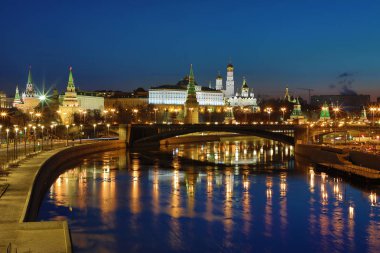 Yükselen güneşin ışınlarına Moskova Kremlin ve Bolshoy Kamenny Köprüsü aydınlatılmış. Rusya 'daki Patriarshy yaya köprüsü 'nden görün. Mavi saatte sabah kentsel manzara