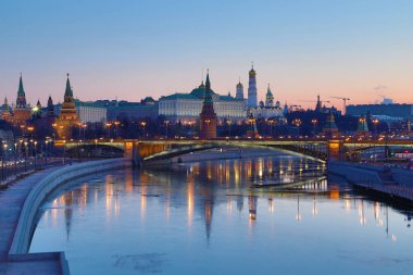 Yükselen güneşin ışınlarına Moskova Kremlin ve Bolshoy Kamenny Köprüsü aydınlatılmış. Rusya 'daki Patriarshy yaya köprüsü 'nden görün. Mavi saatte sabah kentsel manzara