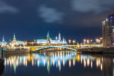Işıklı Moskova Kremlin ve Bolshoy Kamenny köprü de güneş ışınları. Rusya Patriarshy Yaya Köprüsü'nden görüntüleyin. Mavi saat içinde kentsel peyzaj akşam