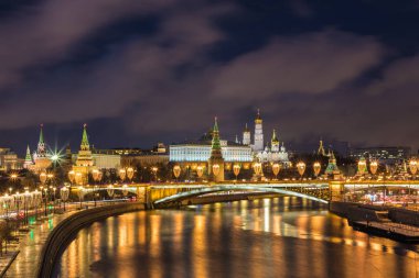 Işıklı Moskova Kremlin ve Bolshoy Kamenny köprü de güneş ışınları. Rusya Patriarshy Yaya Köprüsü'nden görüntüleyin. Mavi saat içinde kentsel peyzaj akşam