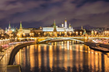Işıklı Moskova Kremlin ve Bolshoy Kamenny köprü de güneş ışınları. Rusya Patriarshy Yaya Köprüsü'nden görüntüleyin. Mavi saat içinde kentsel peyzaj akşam