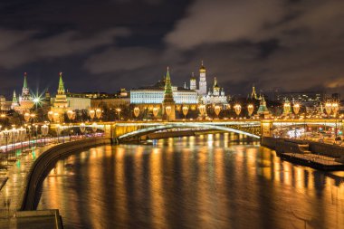 Işıklı Moskova Kremlin ve Bolshoy Kamenny köprü de güneş ışınları. Rusya Patriarshy Yaya Köprüsü'nden görüntüleyin. Mavi saat içinde kentsel peyzaj akşam