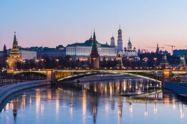 Yükselen güneşin ışınlarına Moskova Kremlin ve Bolshoy Kamenny Köprüsü aydınlatılmış. Rusya 'daki Patriarshy yaya köprüsü 'nden görün. Mavi saatte sabah kentsel manzara